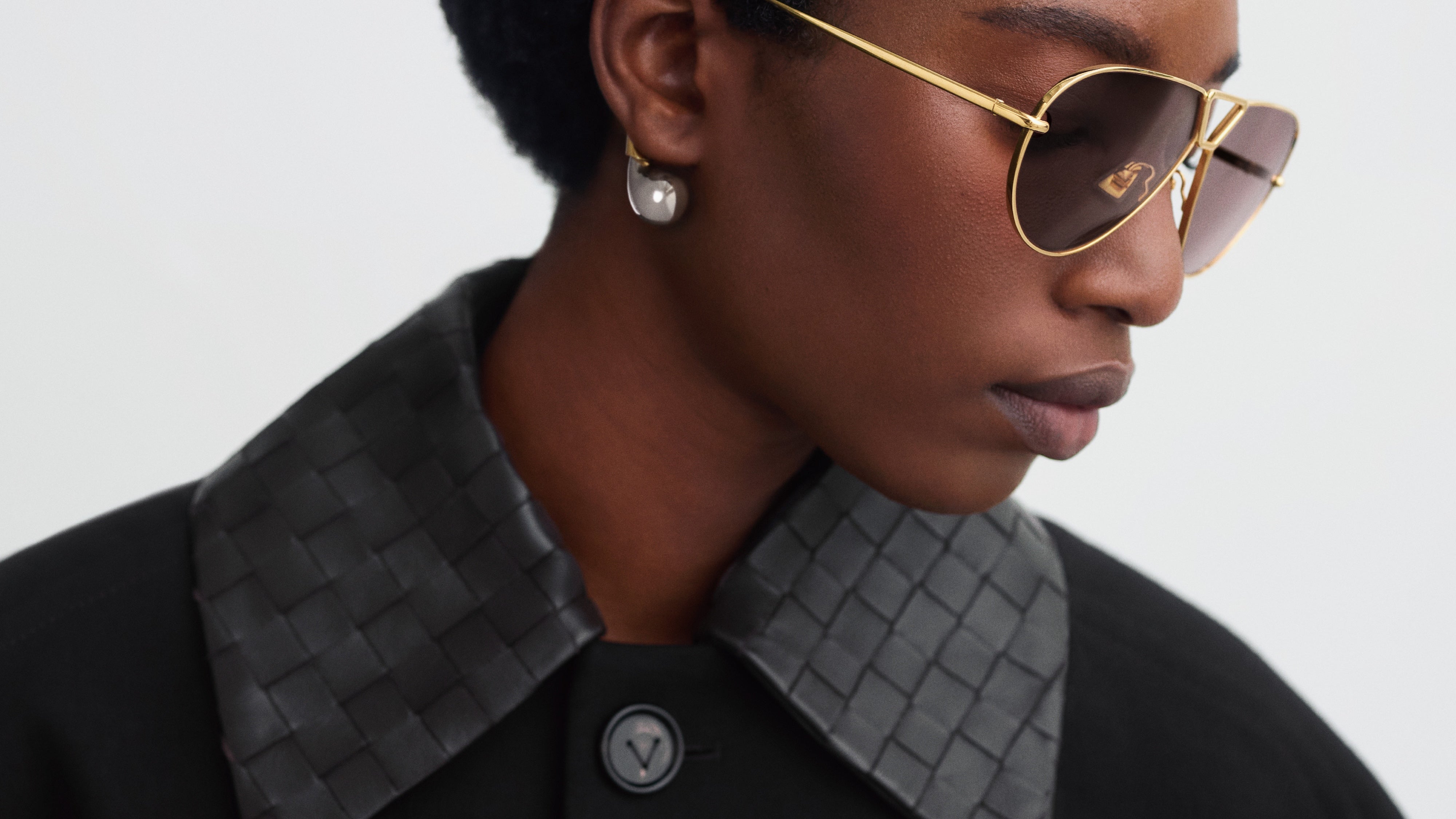 Model wearing Bottega Veneta designer sunglasses from ICONS Miami, crafted with modern Italian luxury design